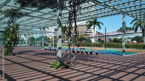 Fototapeta Outdoor park with a metal structure and palm trees in Panama City, summer day