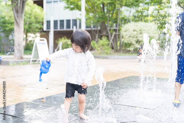 Fototapeta マンション広場の噴水で遊ぶ日本人の幼児