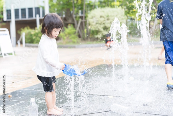 Fototapeta マンション広場の噴水で遊ぶ日本人の幼児