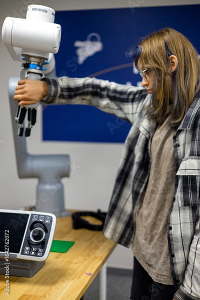 Fototapeta Person interacting with a robotic arm, gripping its mechanical hand in a technology lab, demonstrating human-robot collaboration and modern automation