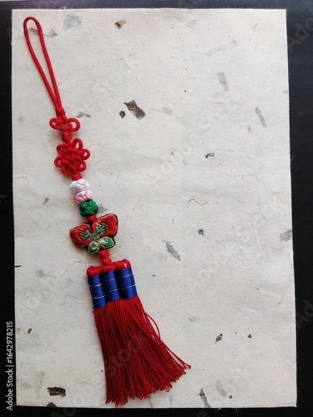 Fototapeta Traditional Korean handmade colorful knots with butterfly embroidered decoration and a piece of traditional Korean handmade paper Hanji