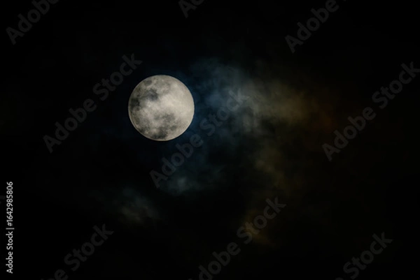 Fototapeta full moon in the midnight behind the cloudy sky