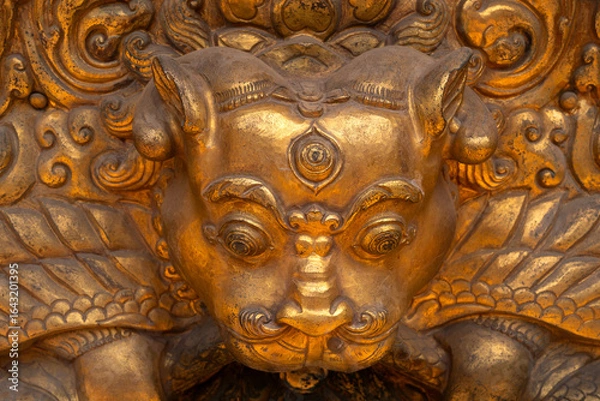 Fototapeta Close-up view of a wrathful Tibetan Buddhist deity in gold ornamental statue, symbolizing protection and the destruction of evil spirits.