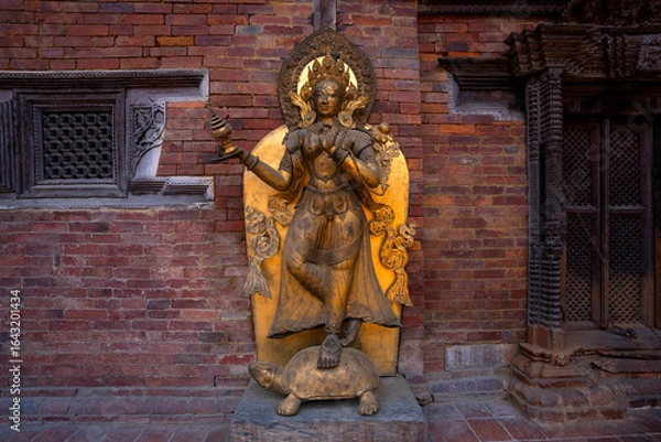 Fototapeta Close-up look of a Tibetan Buddhist woman deity in gold statue, symbolizing protection and the destruction of evil spirits.