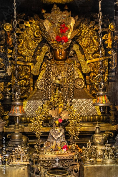 Fototapeta Close-up view of a Tibetan Buddhist man deity in gold ornamental altar statue, symbolizing protection and the destruction of evil spirits.