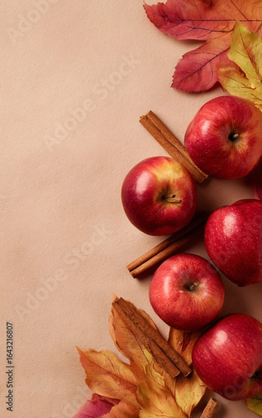 Fototapeta Apples with cinnamon sticks and autumn leaves on beige. Fall harvest concept for thanksgiving day card, autumn season greetings, and cooking recipe background