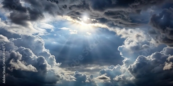 Fototapeta grey clouds in the sky with sun peeking through gaps