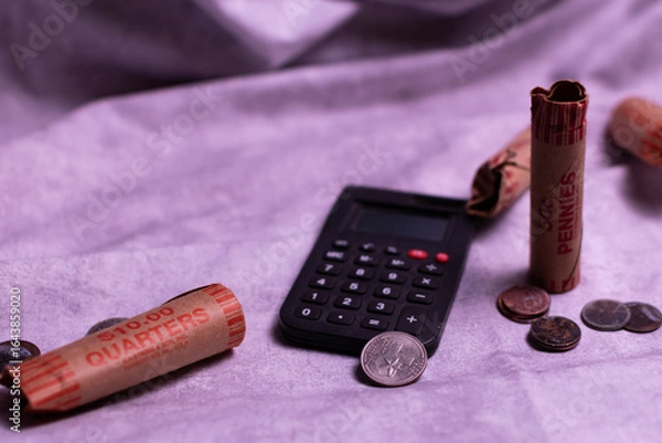 Fototapeta Setting for calculating bills and finances with coins and change rollers.
