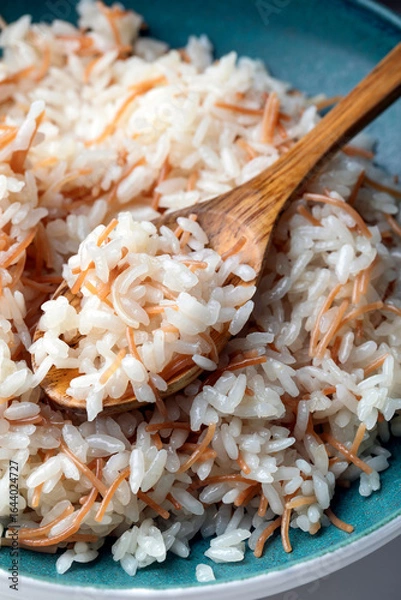 Fototapeta "Close-up of a plate of Turkish rice pilaf with vermicelli, served with a wooden spoon.