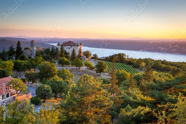 Fototapeta Widok na wioskę Aiguines z uroczym zamkiem i kościołem z widokiem na jezioro Lac de Sainte Croix, departament Var, Prowansja, Francja