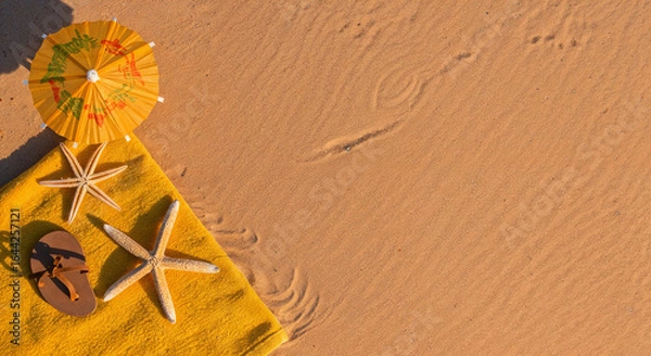 Fototapeta top view of paper beach with yellow towel, umbrella and starfishes on sand near ocean