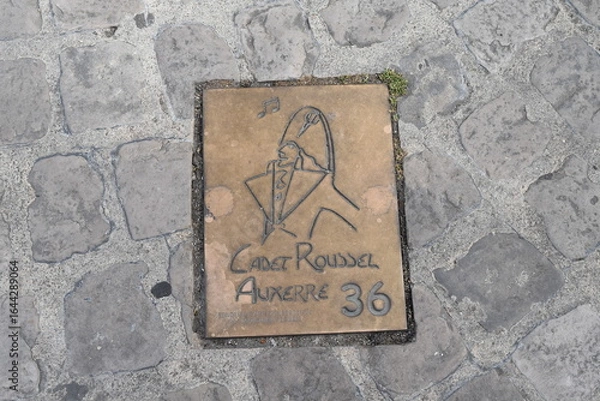 Obraz Bronze scellée dans le sol, à léffigie du Cadet Roussel, marquant une étape d'un circuit de découverte du patrimoine de la ville d'Auxerre.