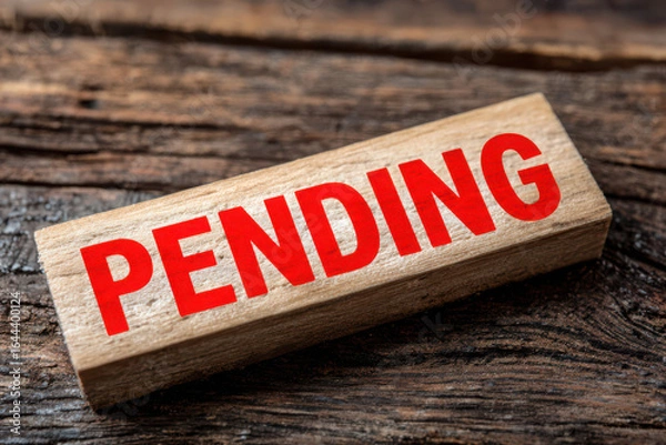 Fototapeta Wooden block with pending in red text on a rustic wooden surface close up studio shot for business use