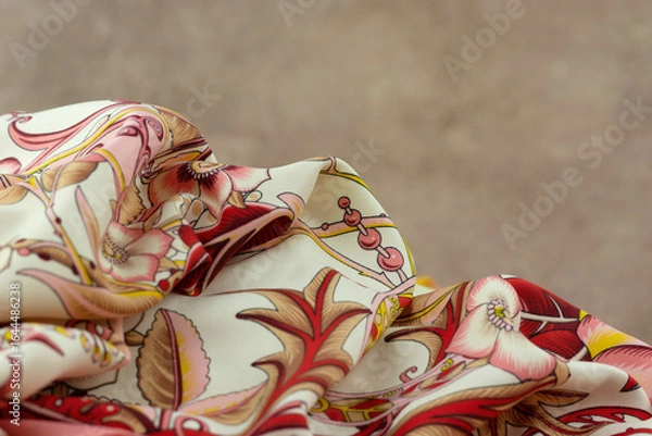 Fototapeta Silk colorful fabric on abstract textured background. Soft delicate fabric for sewing close-up.