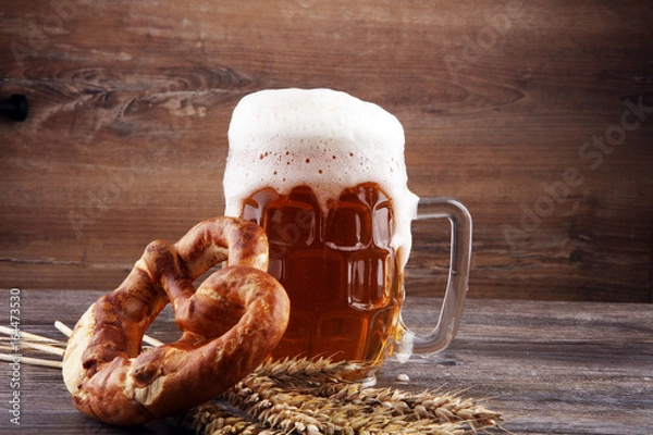 Fototapeta Beer in a mug. Oktoberfest salted soft pretzels and beer from Germany