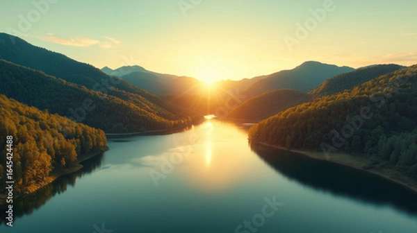 Fototapeta Serene Sunset Over Tranquil Lake Surrounded by Lush Green Mountains and Reflections in Calm Waters