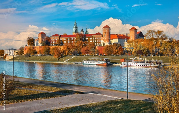 Fototapeta Krakow Poland. Wawel castle the Wisla river banks. Autumn sunset with blue sky and white clouds. Sunny evening scene.