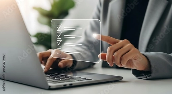 Fototapeta Woman checking off items on a digital checklist on laptop