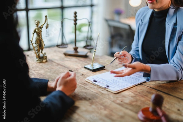 Fototapeta Lawyer explaining contract details to client during meeting in office