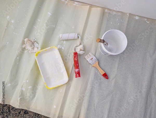 Fototapeta Paint tray with white roller and various painting tools arranged for interior home renovation project