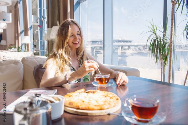 Obraz Pretty Young Woman Sitting in the Cafe with a Cup of Tea. Looking in the Window