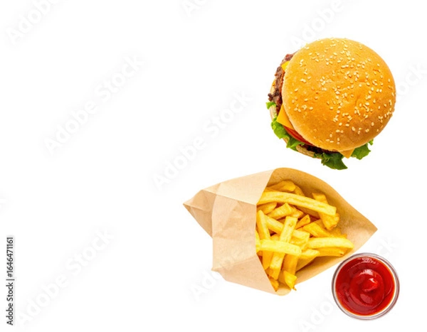 Fototapeta Topdown view of a classic cheeseburger meal with golden french fries in a paper bag and a side of ketchup.