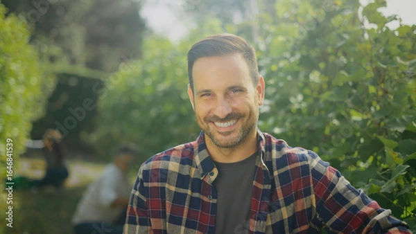 Obraz Winemaker smiling in vineyard during grape harvest