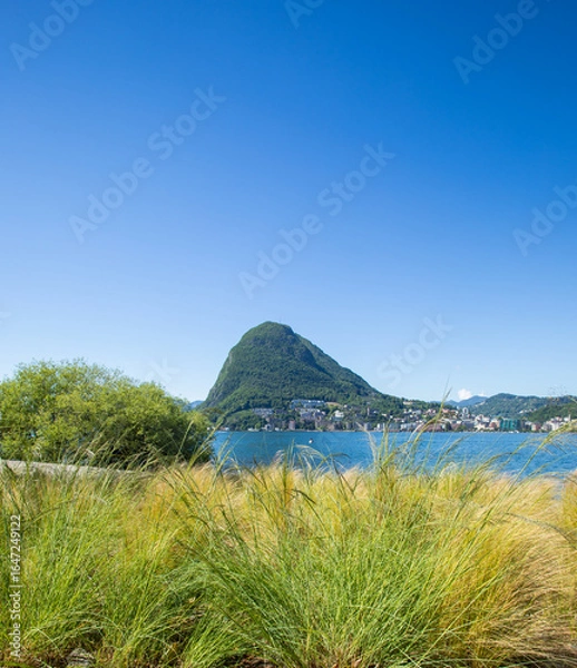 Fototapeta View of Lugano's lake and Mount San Salvatore in Svittera. Fantastic weather with sunny summer and spring day and blue sky.  Silence