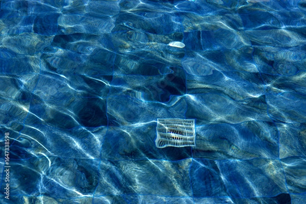 Obraz Rippled Blue Water Surface with Sunlight Reflections and Floating Objects