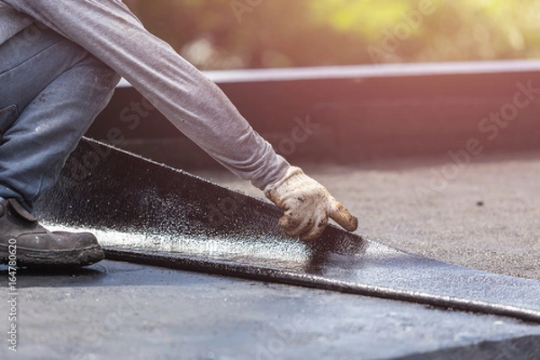 Fototapeta Group of worker installing tar foil on the rooftop of building. Waterproof system by gas and fire torching