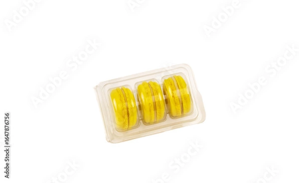 Fototapeta Yellow macaroons in transparent packaging on white background