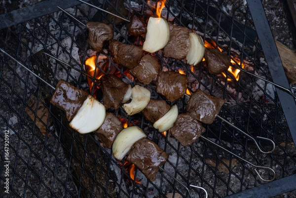 Fototapeta beef and onion shish kebab on the grill