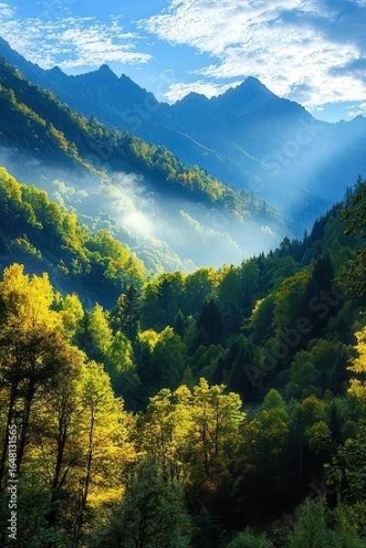 Fototapeta Lush green mountains bask in sunlight, with mist weaving through the trees, creating a serene and picturesque landscape under a bright blue sky.