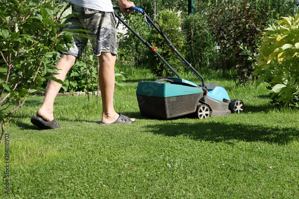 Obraz Senior man mowing lawn