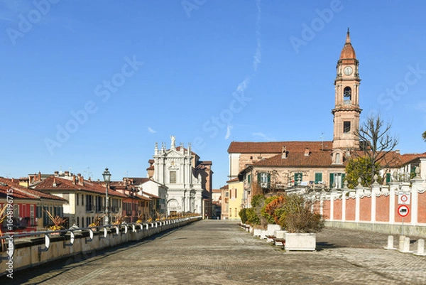 Fototapeta Corso Cottolengo, place where is located the birthplace of St Giuseppe Benedetto Cottolengo, with the churches of Santissima Trinità (right) and Sant'Andrea, Bra (Cuneo), Piedmont, Italy