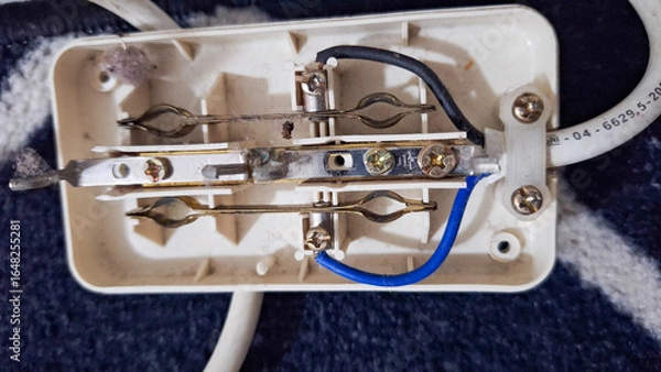 Fototapeta Internal wiring of a multiplug extension cord, revealing a potentially hazardous setup. broken electrical socket.