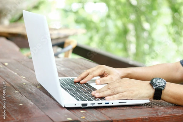Fototapeta Stock photo :.Closeup image of a hands working and typing on laptop keyboard with blur nature background