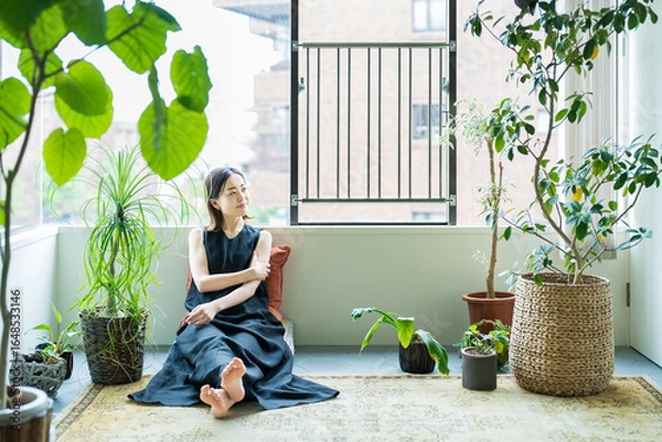 Obraz 観葉植物に囲まれてリラックスする女性