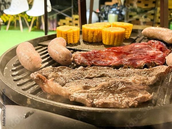 Fototapeta ジュージューと焼かれる肉とソーセージのバーベキューアップ写真