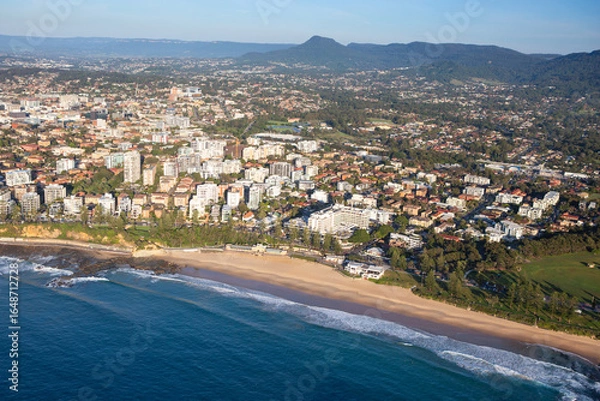 Fototapeta Wollongong's iconic North Beach, located an hour south of Sydney is a well known tourist destination. Captured from high above looking west towards the escarpment.