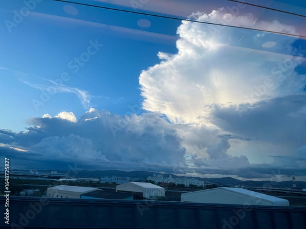 Obraz 青空に浮かぶ積乱雲と新幹線の車窓から見た工業地帯の風景
