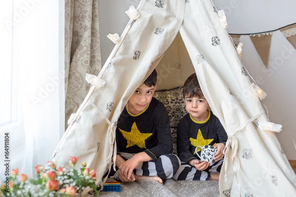 Fototapeta Brothers playing in a teepee