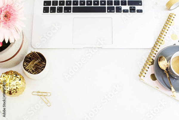 Fototapeta Feminine workplace concept in flat lay style with laptop, coffee, flowers, golden pineapple, notebook and paper clips on white marble background. Top view, bright, pink and gold