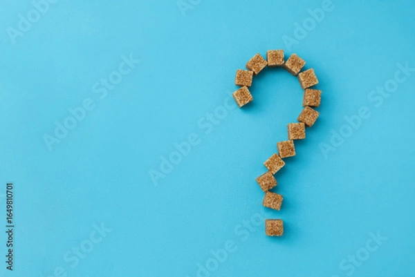 Fototapeta Question mark made of cane sugar pieces. Concept of healthy nutrition and harm of eating sweets. Selective focus, copy space