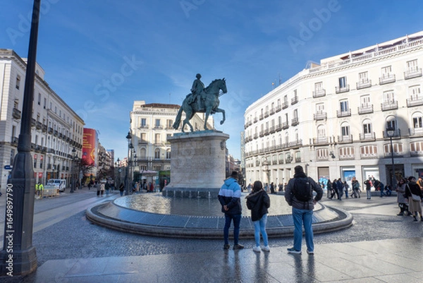 Fototapeta Plaza View: Capturing the spirit of city, the statue in the heart of the plaza. The sky, buildings, and people evoke a sense of urban life and history.