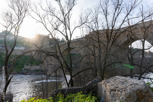Obraz Toledo Old Bridge – The historic San Martín Bridge in Spain gracefully spans the tranquil Tagus River with majestic medieval stone arches and towers, steeped in history and culture