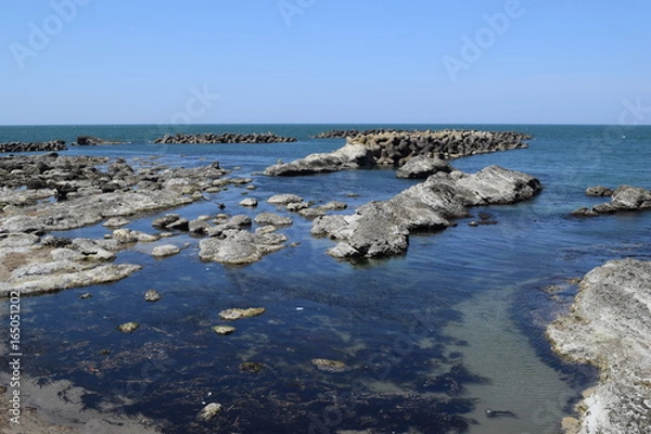 Fototapeta 湯野浜海岸の岩場風景 ／ 山形県の湯野浜海岸は、非常にきれいな白砂と奇岩怪石の磯が続く、素晴らしい景観のリゾート地です。湯野浜は全国の名所の中から「日本の夕陽百選」にも選ばれたエリアです。日本海に沈む夕陽は大変素晴らしい景観で、日本海トップランクのリゾート地として、五感の全てを満たす多くの魅力にあふれたエリアです。