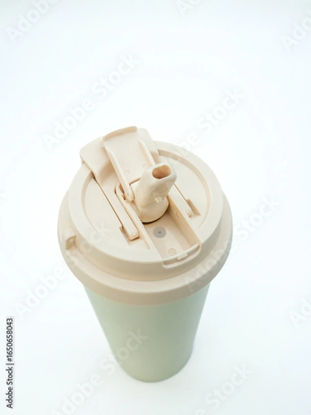 Obraz Beige open thermo mug with lid and straw on white background, close-up top view