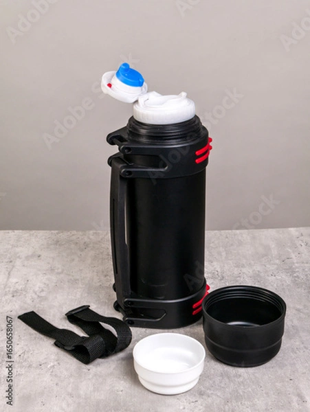 Obraz An open black thermos with cups stands on the table