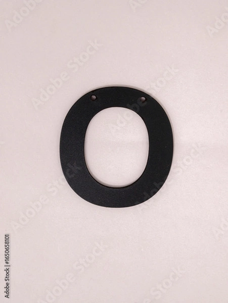 Obraz Wooden black letter O on a gray background with holes for a rope